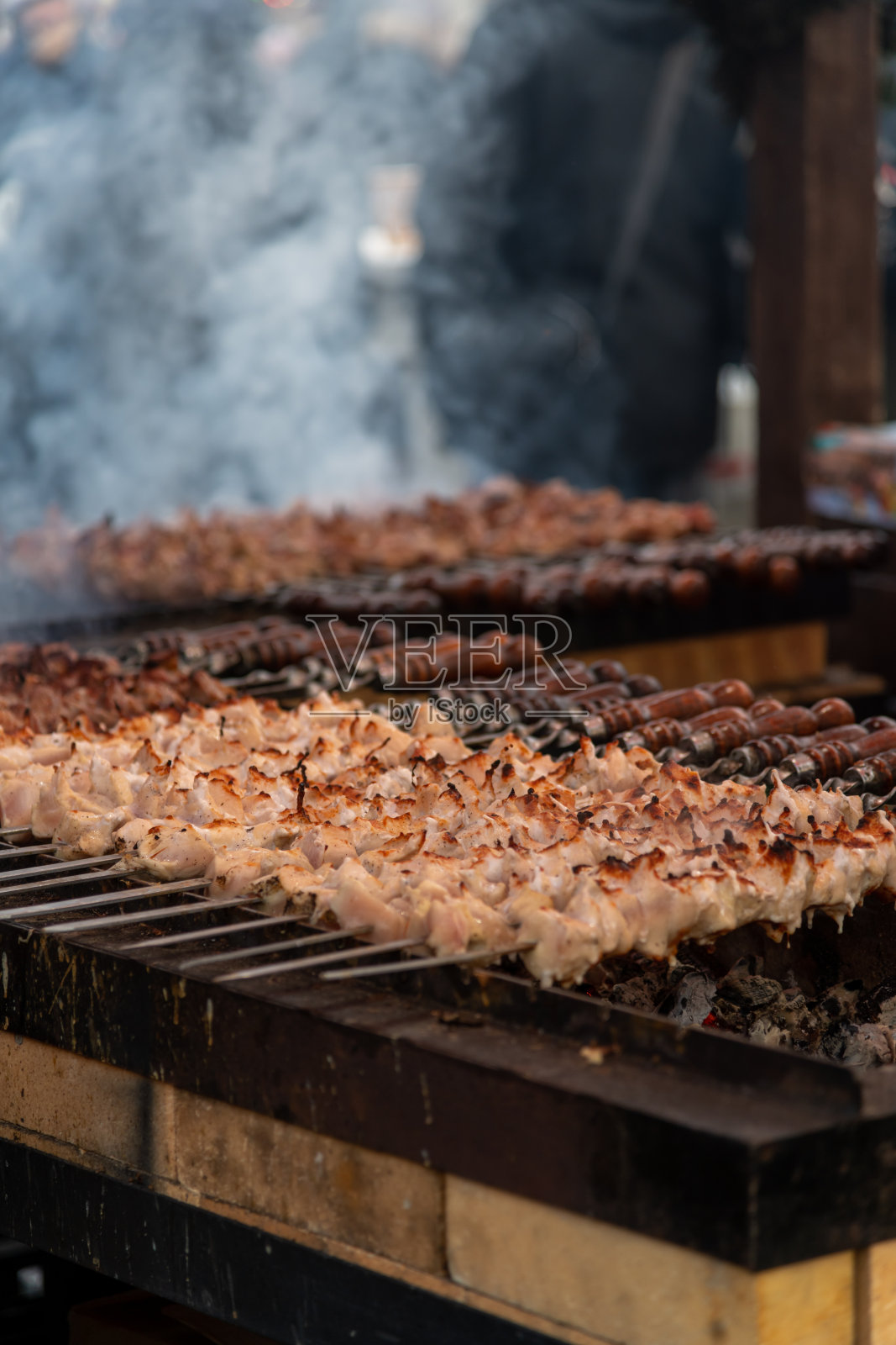 在热闹的夜晚活动中，户外市场上烤制串烧照片摄影图片