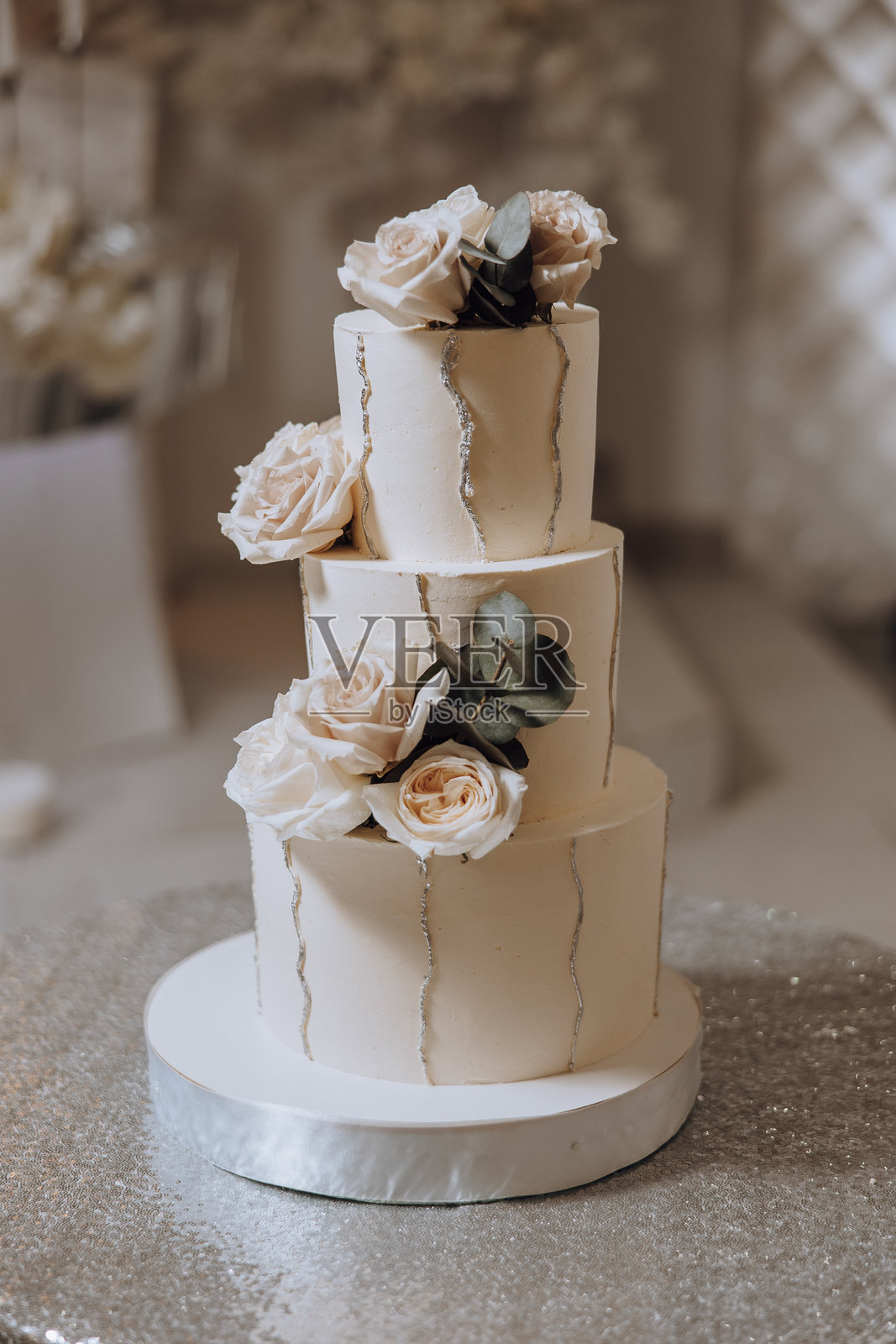 三层婚礼蛋糕，上面装饰着白色糖霜和花朵照片摄影图片