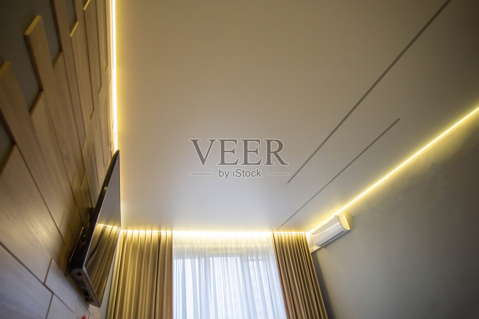 美丽的现代拉伸天花板，周边有黄色LED灯带。大厅内的时尚设计天花板。照片摄影图片