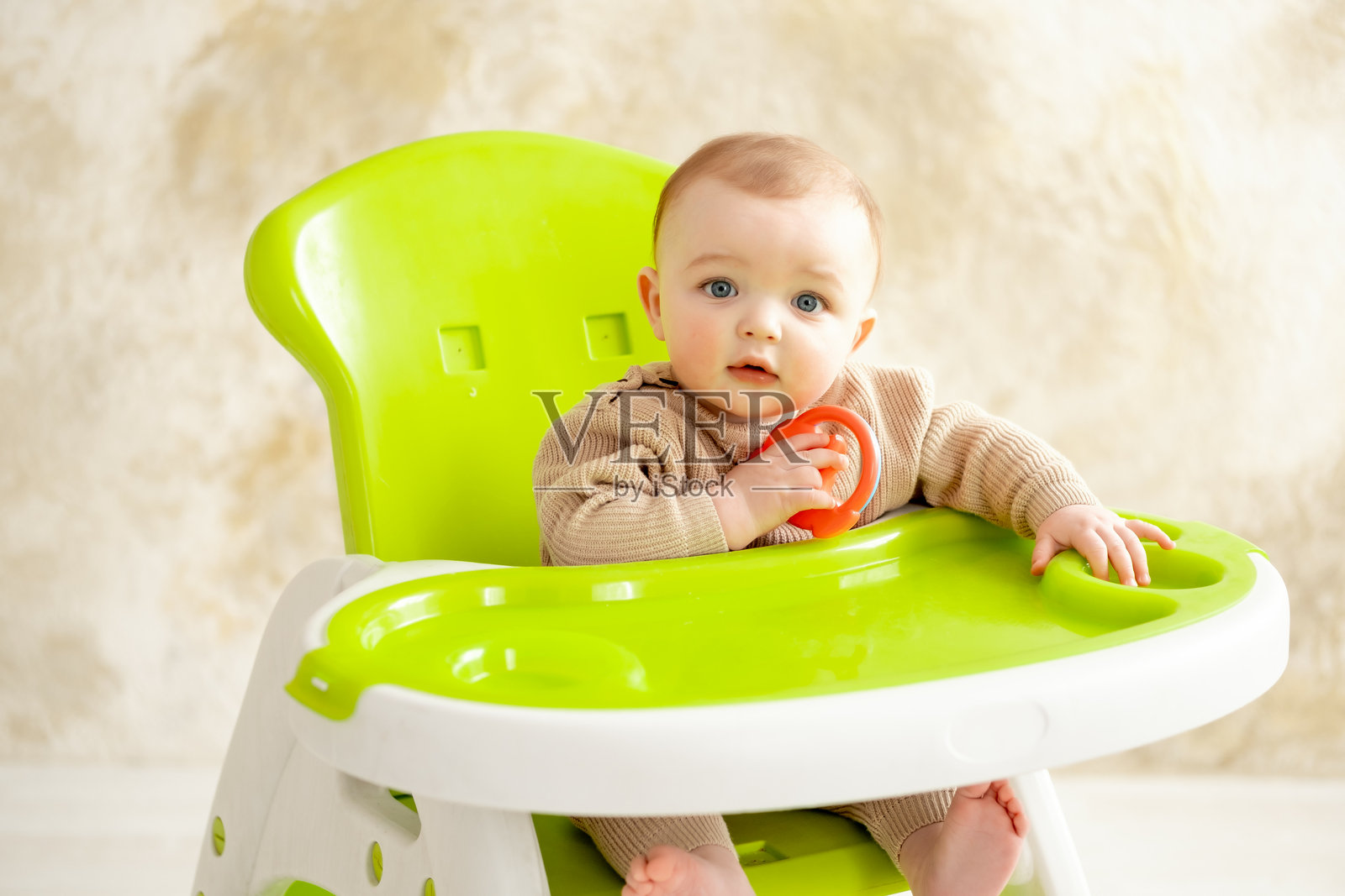 一个坐在绿色高脚椅上的婴儿正在吃婴儿食品，适合放置文本的空间和位置照片摄影图片