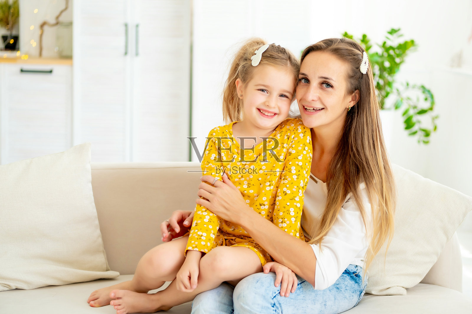 一位母亲与孩子的肖像，母亲在家中与女儿玩耍并逗她笑，享受快乐的时光，幸福的家庭和欢笑的孩子，母亲身份与生活方式照片摄影图片