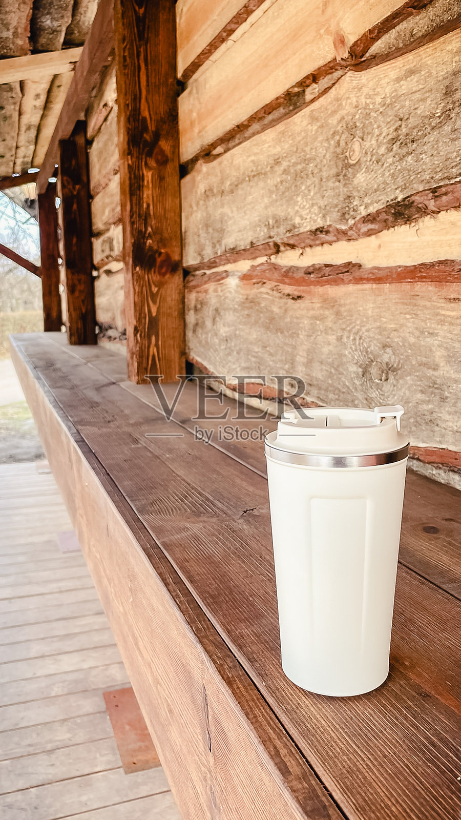 手中拿着米色保温杯在公园散步照片摄影图片