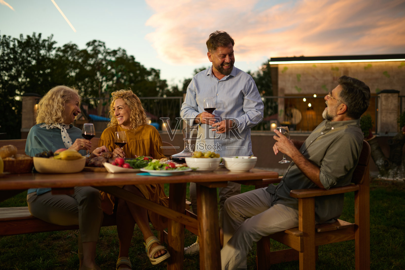 一群成熟的朋友在后院聚会上享受美食和饮品照片摄影图片