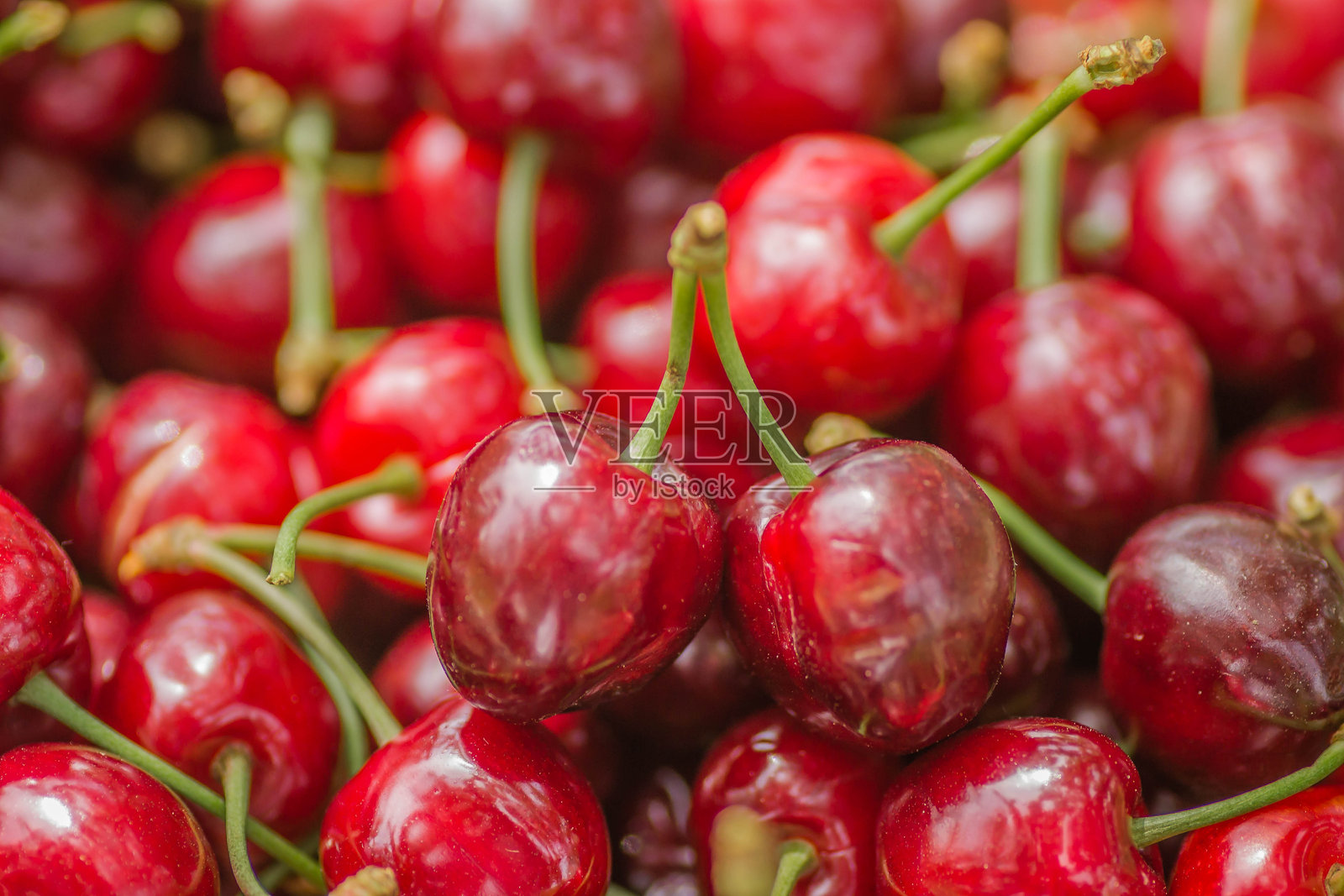 采摘的红色成熟樱桃果实背景。照片摄影图片
