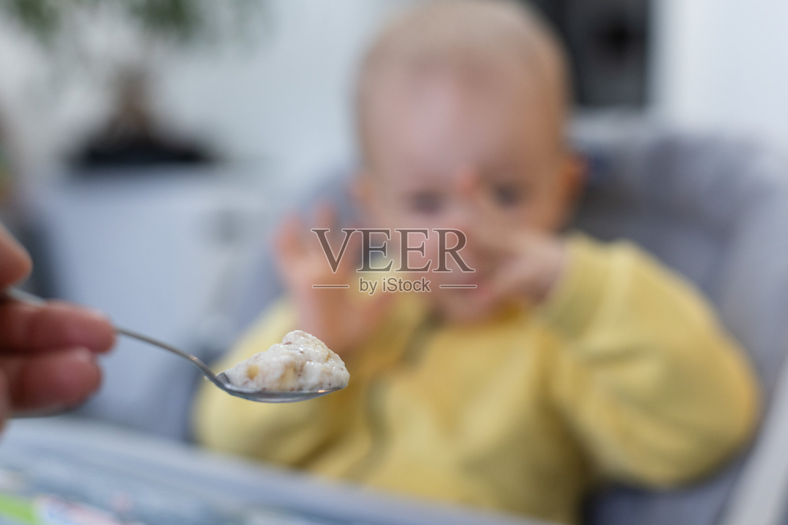 小孩不想吃婴儿粥。婴儿粥的勺子。选择性对焦。照片摄影图片