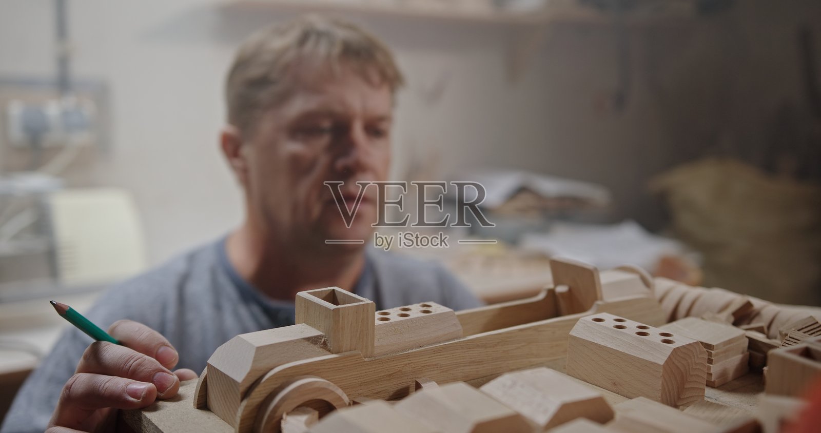 一位技艺精湛的工匠专注于制作复杂精细的木制模型照片摄影图片