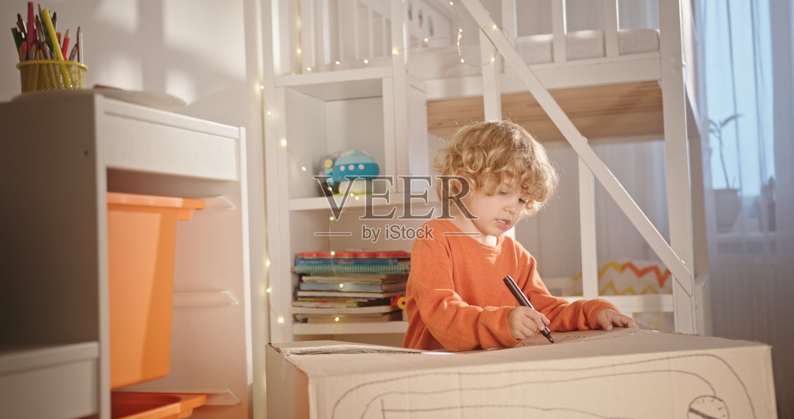 一个年轻孩子的富有想象力的画作展示在一个温暖舒适、充满欢乐的游戏室里照片摄影图片