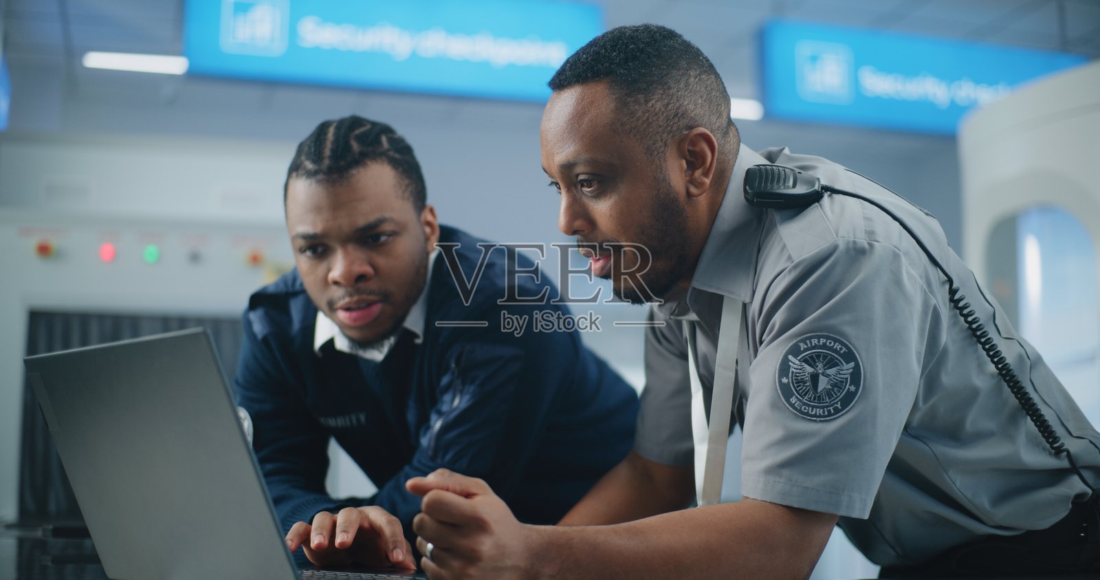 机场安检站：TSA工作人员使用笔记本电脑，讨论安全问题照片摄影图片