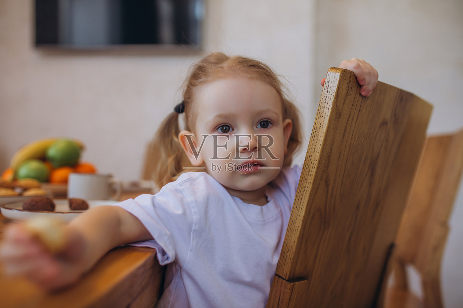 小女孩在桌子上吃饼干的特写肖像照片摄影图片