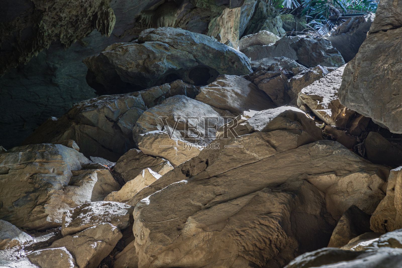 复杂的阳光透过洞穴照射到Hup Pa Tat洞穴内的钟乳石上。照片摄影图片