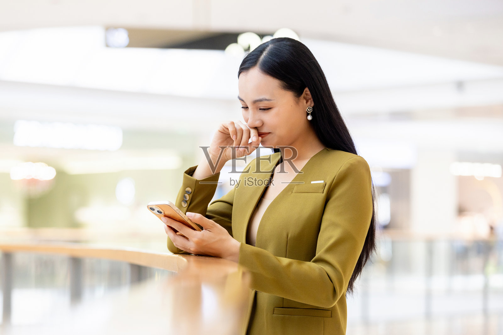 中国女商人在商业大楼内使用手机照片摄影图片