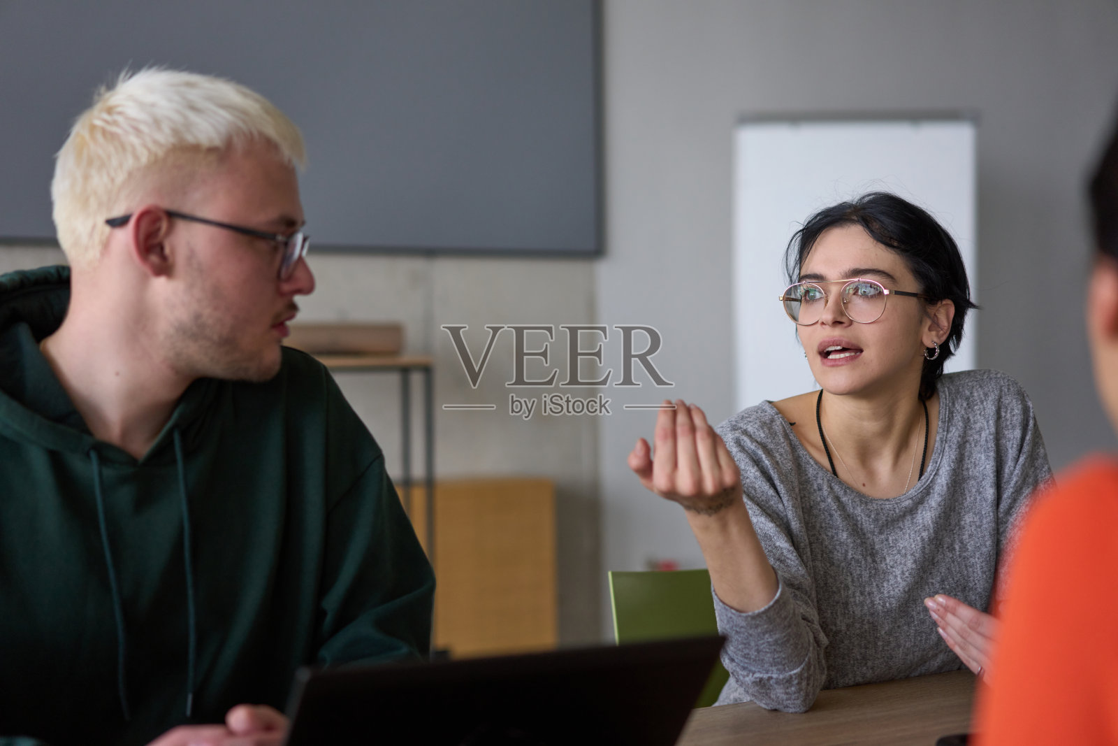 一支年轻多元的商业团队坐在现代办公室里，交流想法和商业计划，促进合作与创新，以实现未来的成功。照片摄影图片