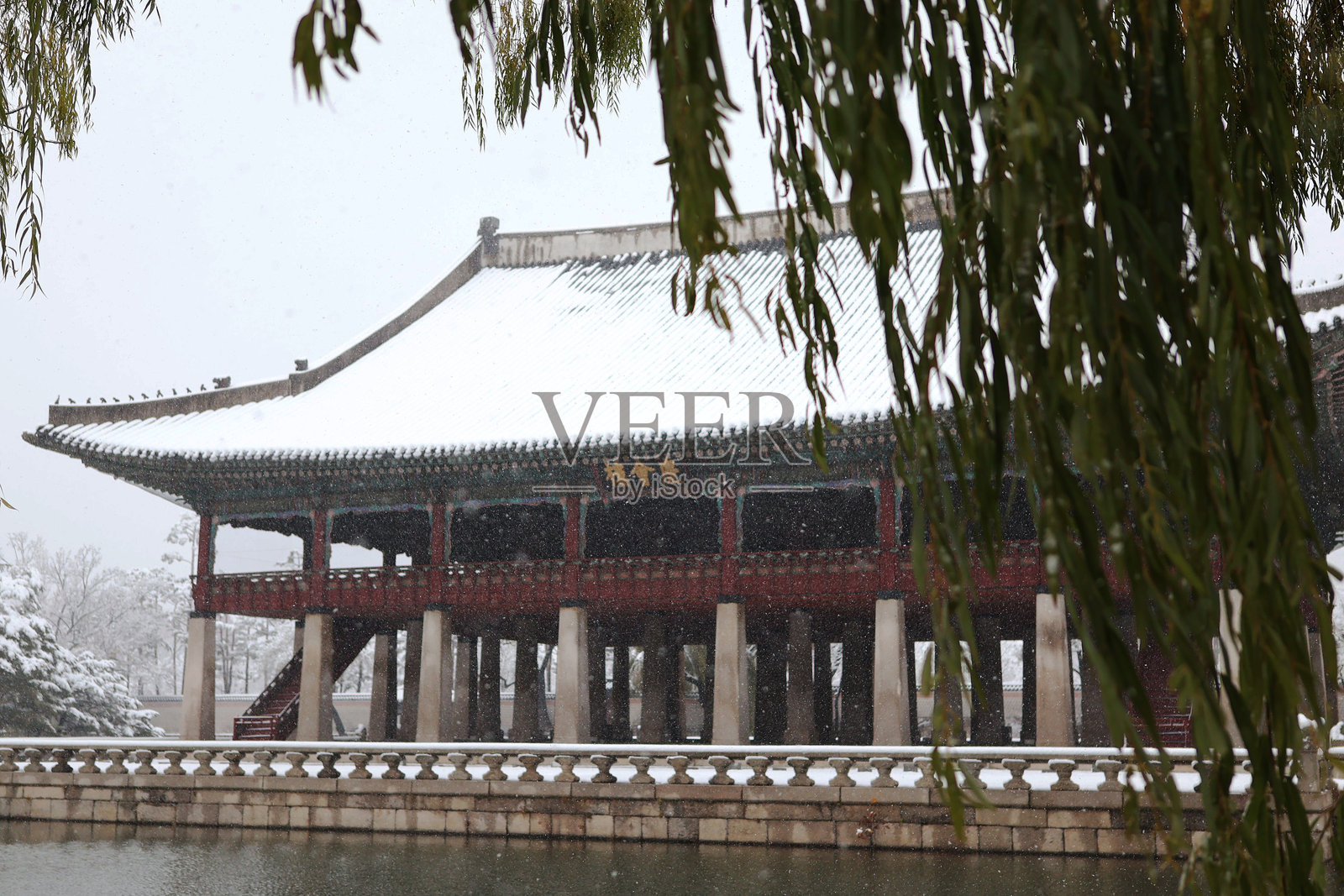 雪覆盖的庆海塔和柳树照片摄影图片