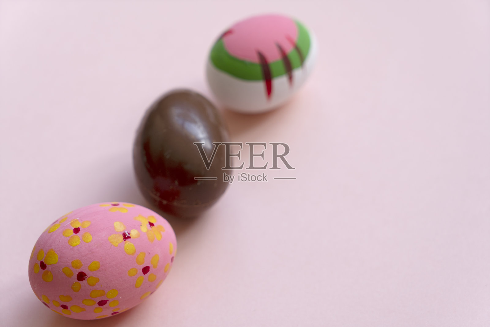 粉色背景上的巧克力复活节彩蛋和复活节彩蛋照片摄影图片