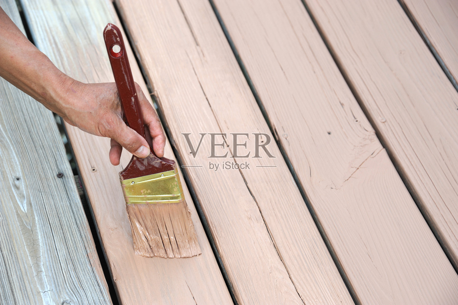 工人用刷子给木甲板上漆照片摄影图片