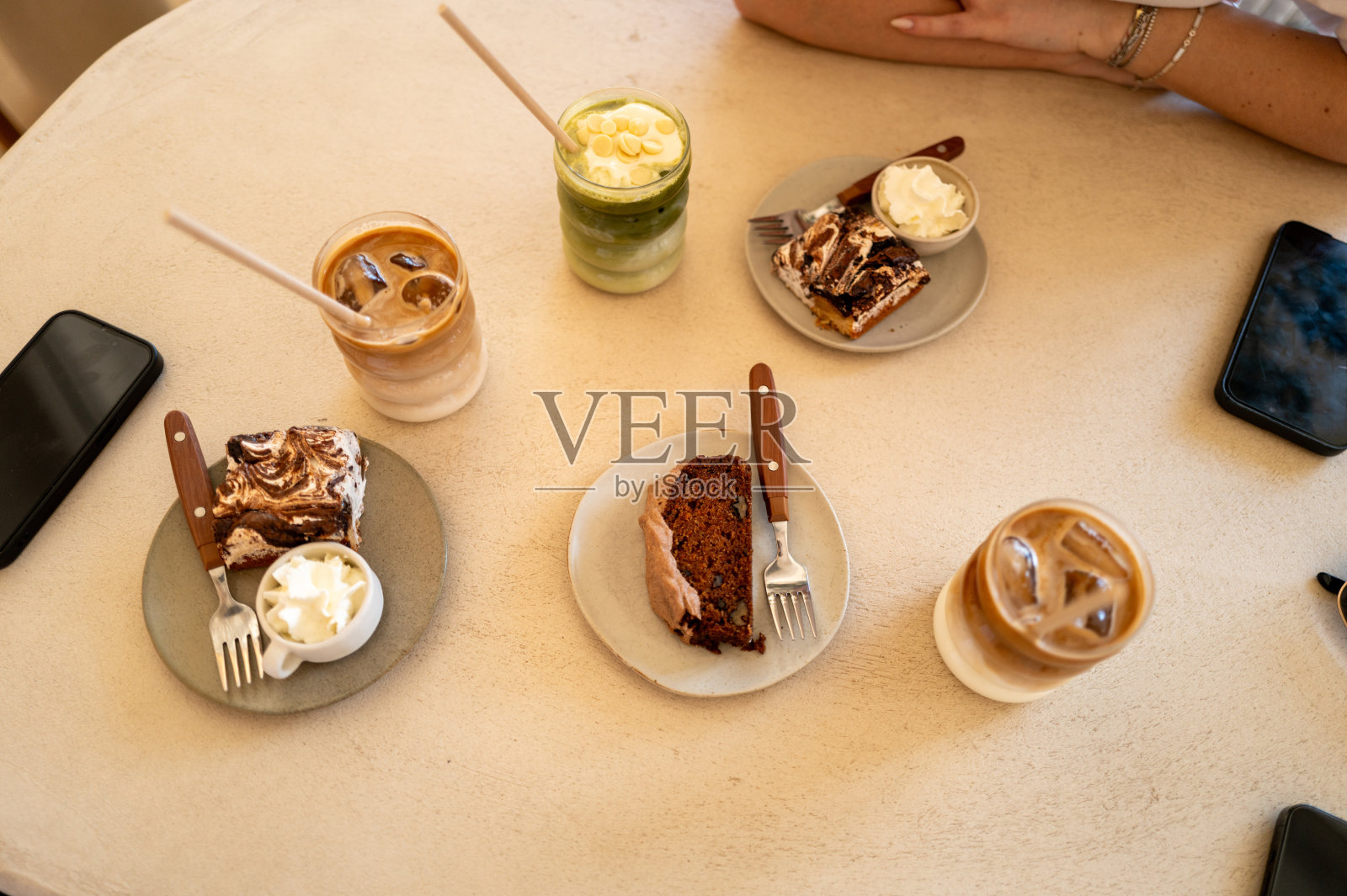 朋友们在咖啡馆享受冰咖啡和蛋糕照片摄影图片