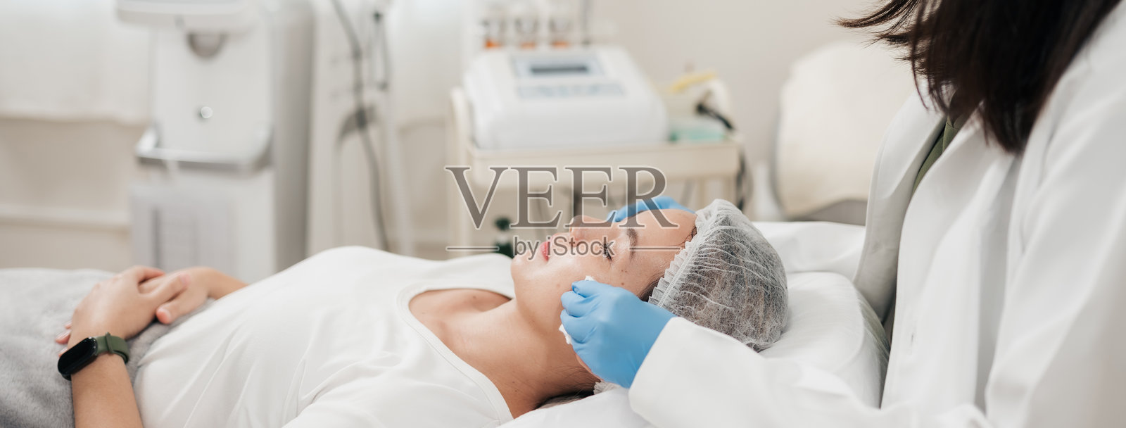 横幅比例，亚洲女性在美容诊所接受美容师清洁面部，为美容注射做准备。照片摄影图片