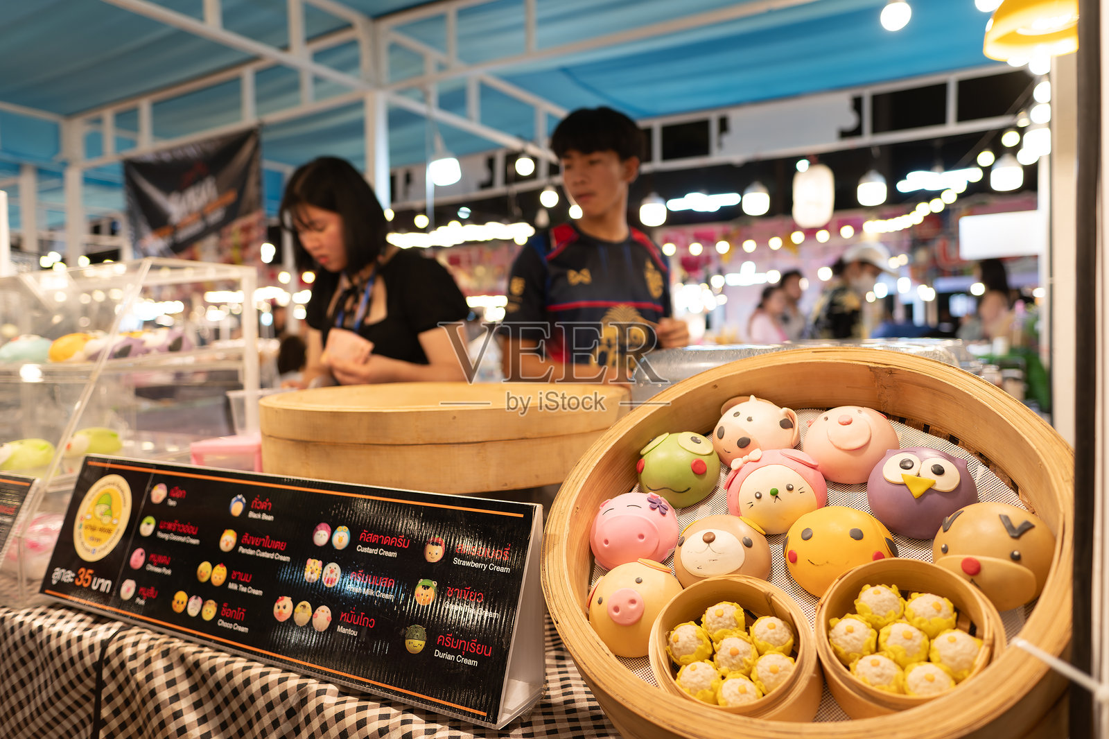 在芭提雅夜市的街头小吃摊位上出售蒸包子照片摄影图片