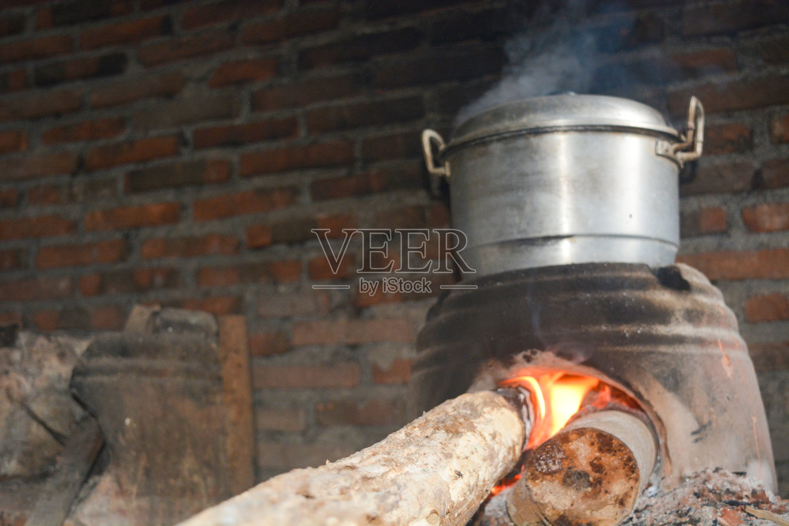 传统烹饪，使用泥土制成的炉灶和正在煮水的火锅照片摄影图片