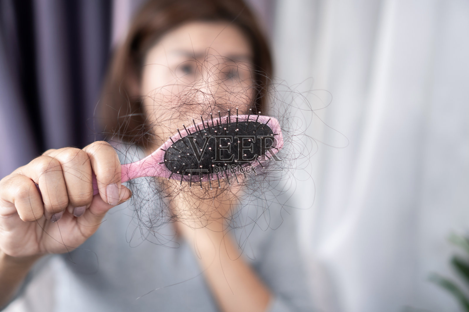 亚洲女性在梳理干燥受损的头发时担心脱发照片摄影图片