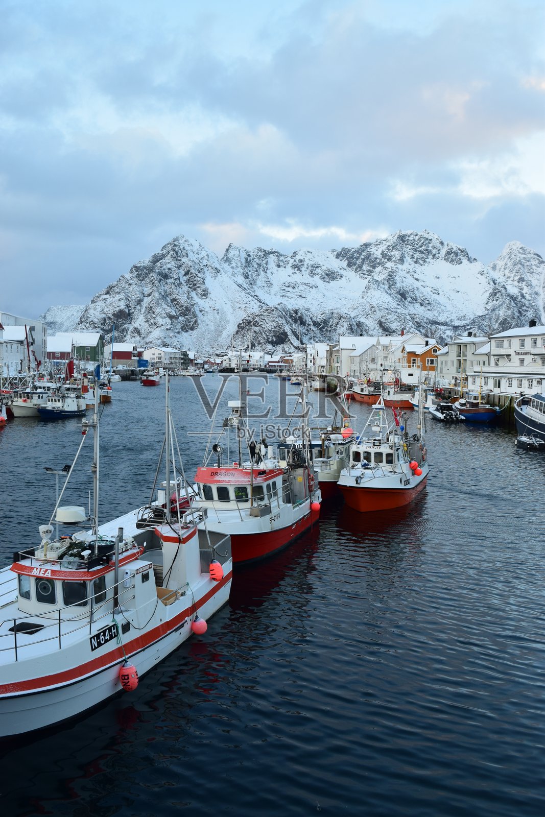 洛福滕群岛的港口里停着渔船，背景是白雪皑皑的山脉照片摄影图片