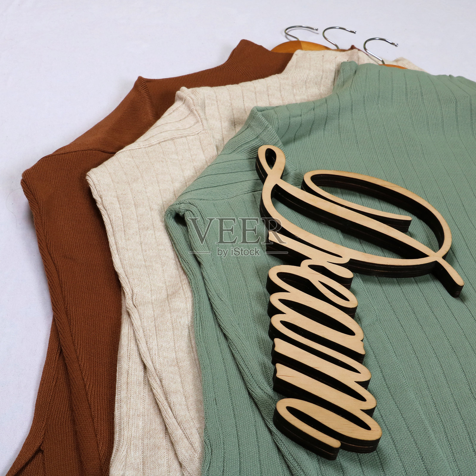 时尚的鼠尾草绿色罗纹针织套装，配有高领长袖上衣和匹配的裙子。非常适合舒适而别致的造型。与干花和“梦想”标志一起展示，营造出柔和的美感。照片摄影图片