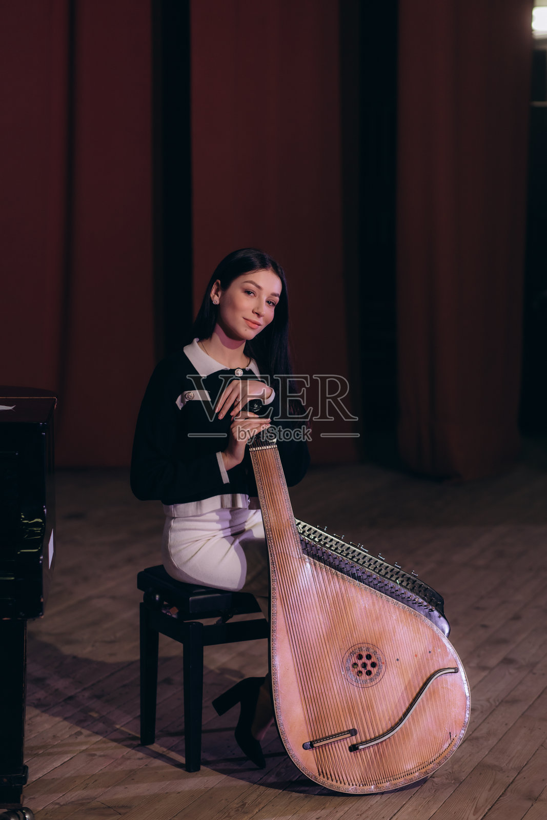 年轻女性在音乐厅演奏班杜拉乐器照片摄影图片