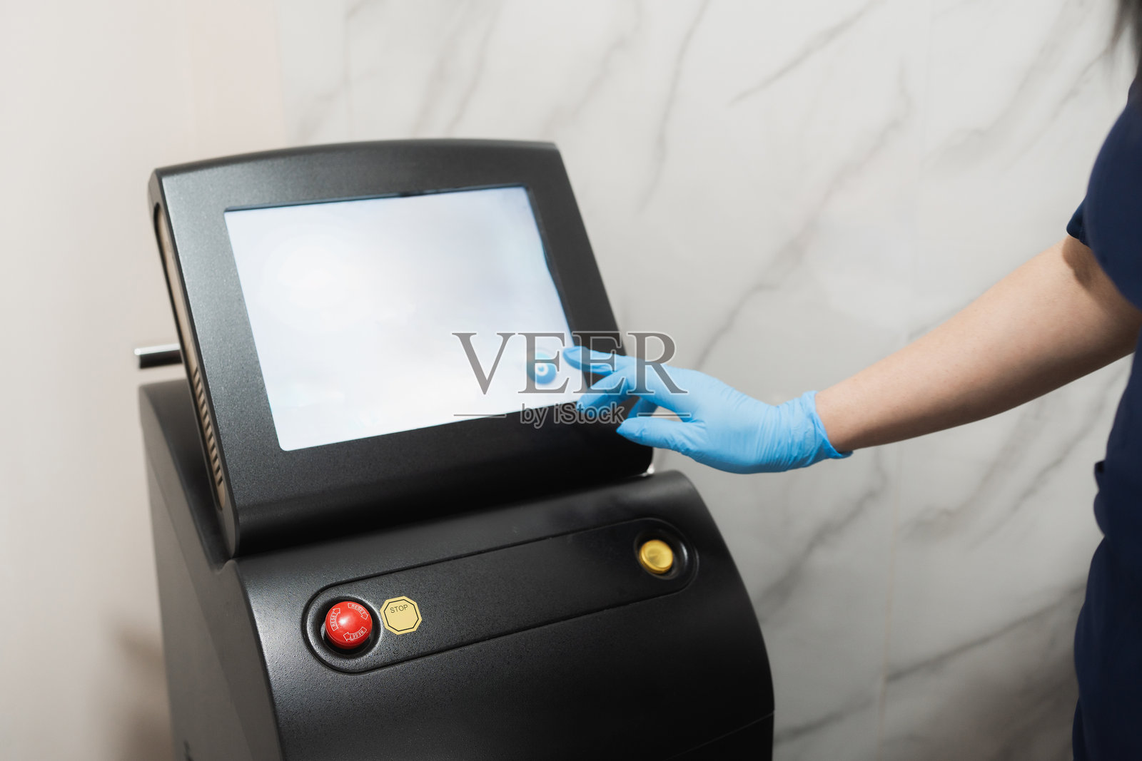 美容师戴着手套使用专业激光脱毛机照片摄影图片