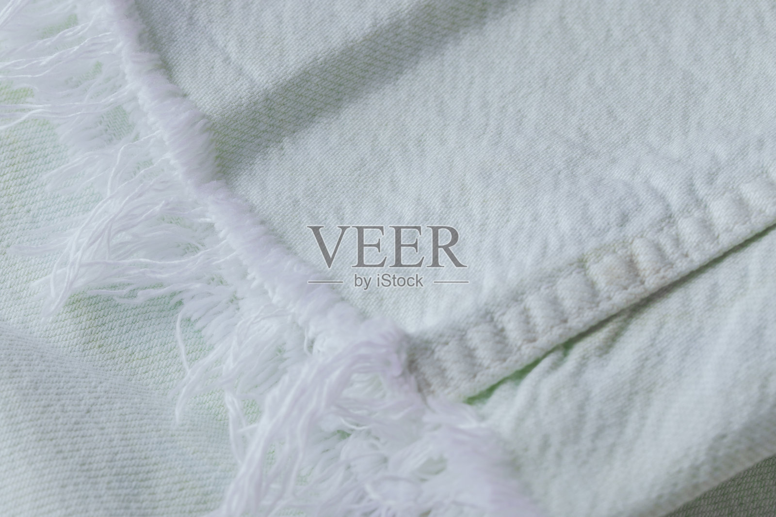 浅薄荷色牛仔裤特写，带有白色流苏，棉质面料纹理照片摄影图片