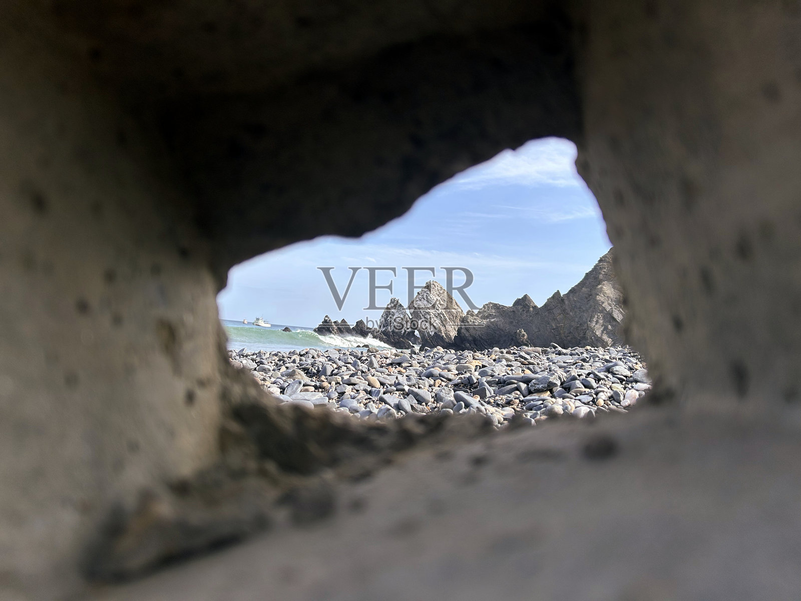 通过自然岩石框架看到的皮乌拉省雅西拉海滩的岩石海滩风景照片摄影图片