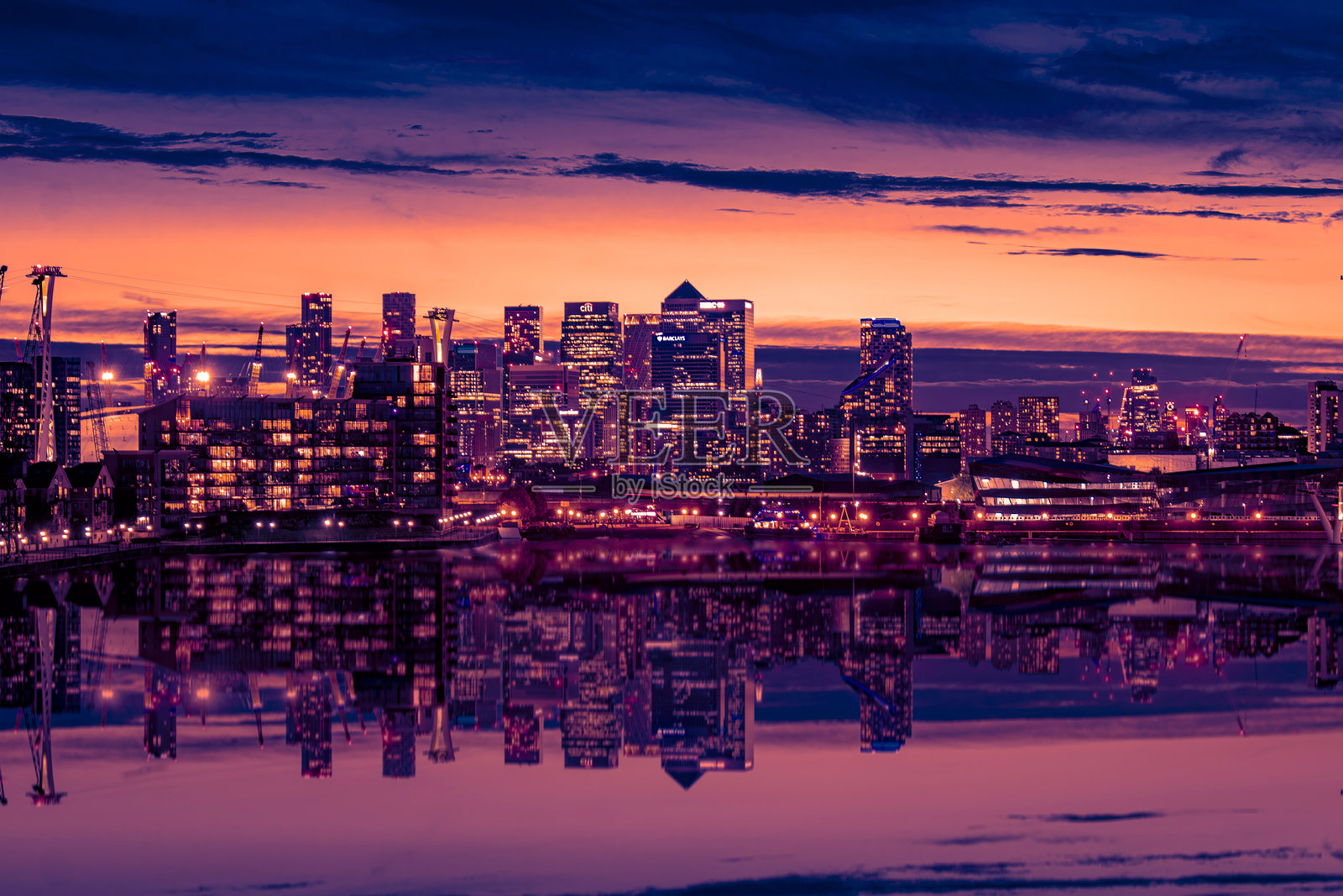 格林威治日落时分的伦敦天际线，缆车倒映在水面上照片摄影图片