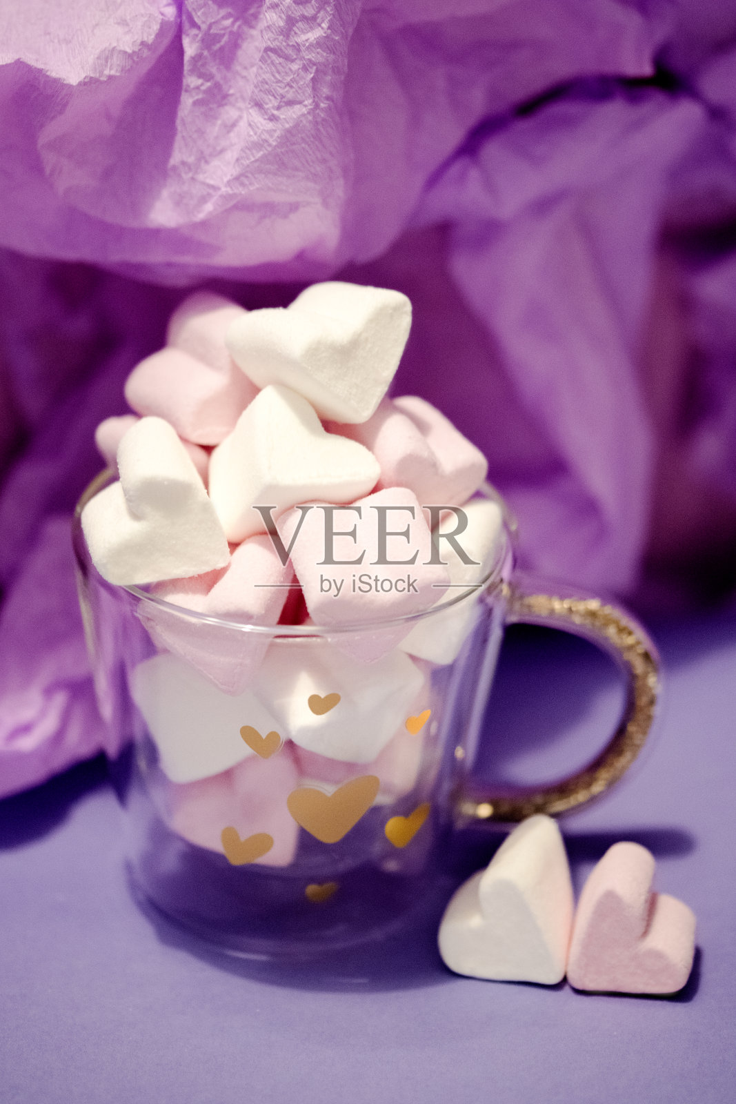 紫色背景下玻璃杯中的心形情人节棉花糖照片摄影图片