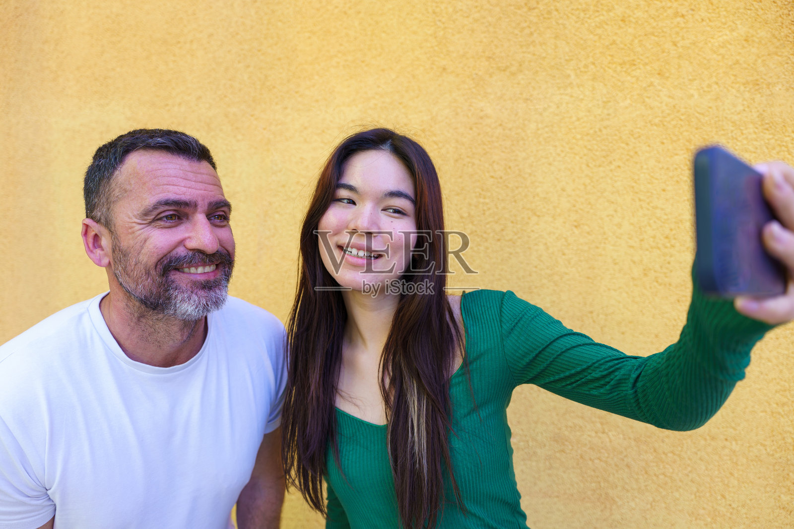 父亲和女儿用智能手机自拍照片摄影图片