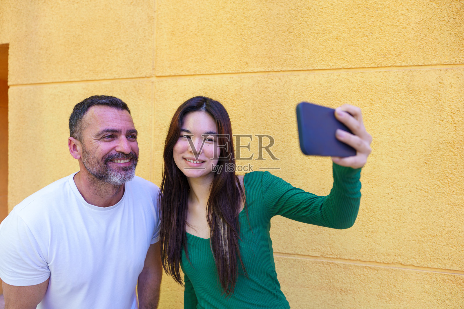 父亲和养女用智能手机自拍照片摄影图片