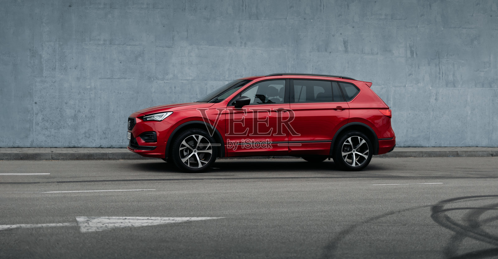 红色SEAT Tarraco停在靠近蓝色墙壁的街道上。照片摄影图片