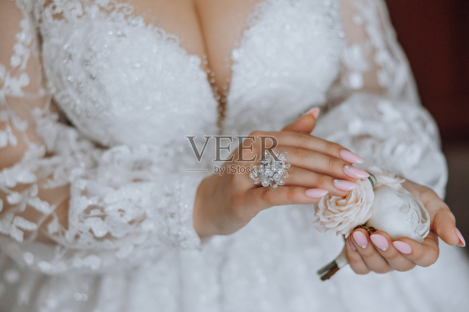 一位女性手中拿着一朵白玫瑰，身穿白色连衣裙。照片摄影图片