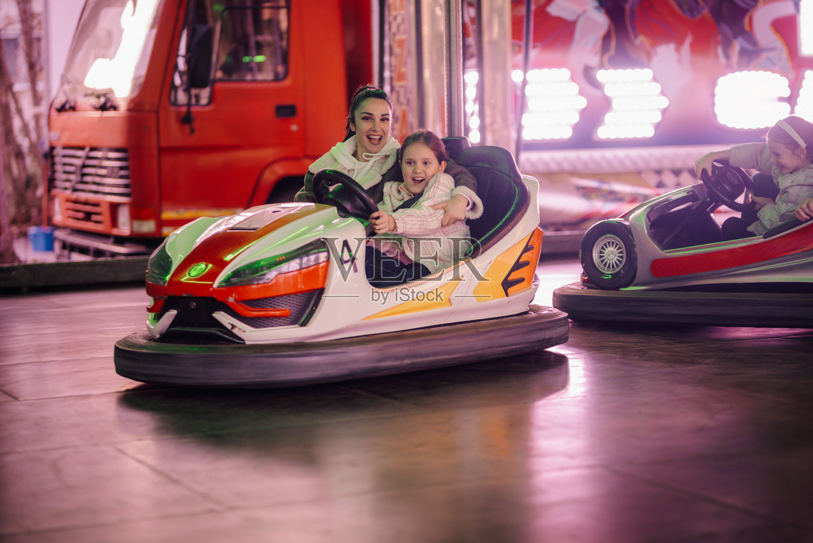 母女在游乐园享受碰碰车的乐趣照片摄影图片