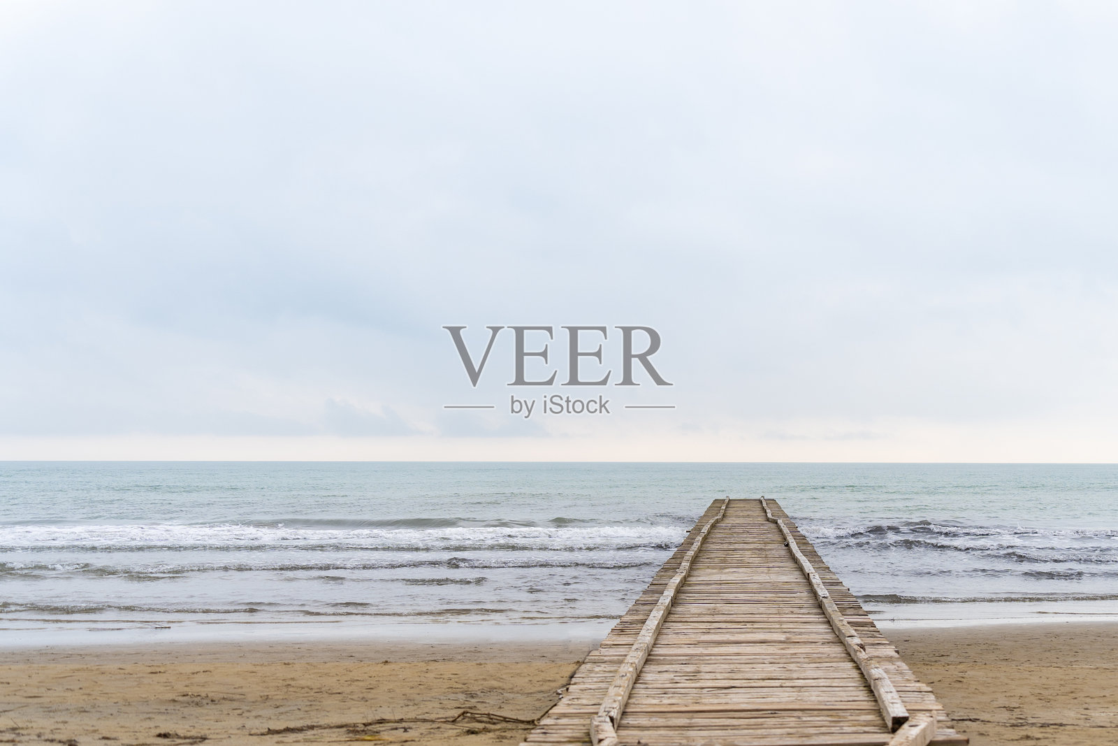 通往意大利秋季多云海滩的亚得里亚海的木栈道照片摄影图片