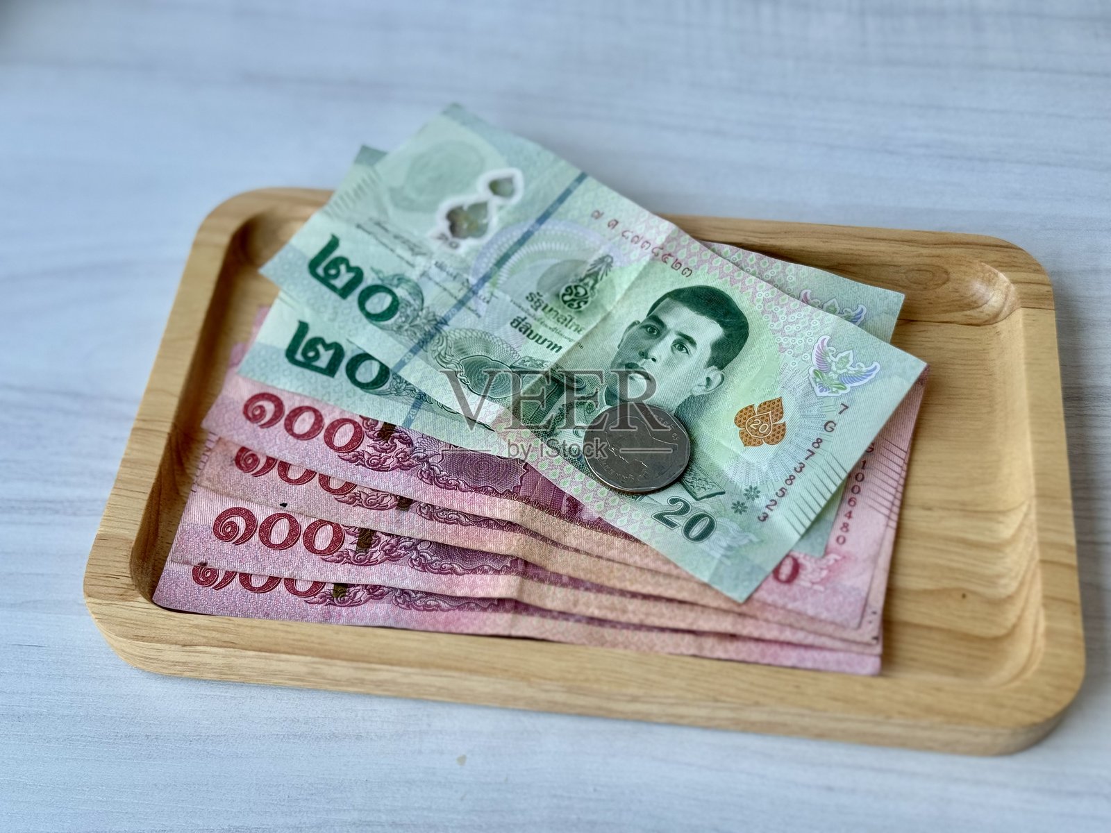 白色背景上的木托盘里的泰铢货币。照片摄影图片