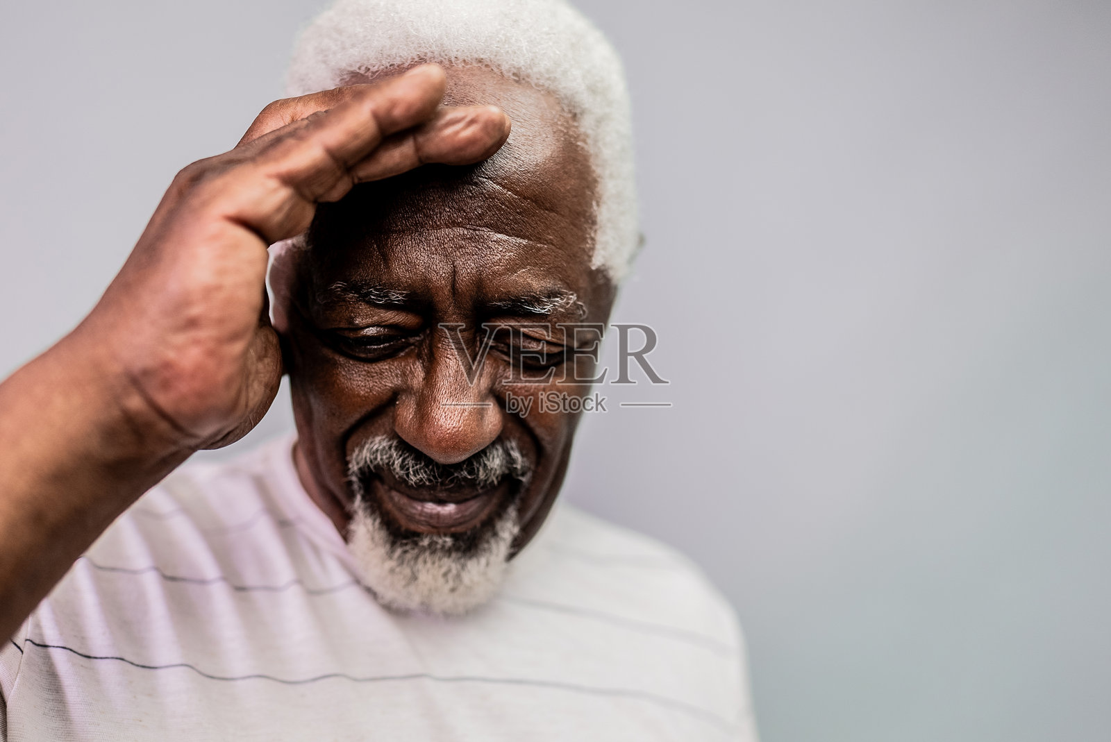 一位头痛的老年男子在灰色背景下的摄影作品照片摄影图片