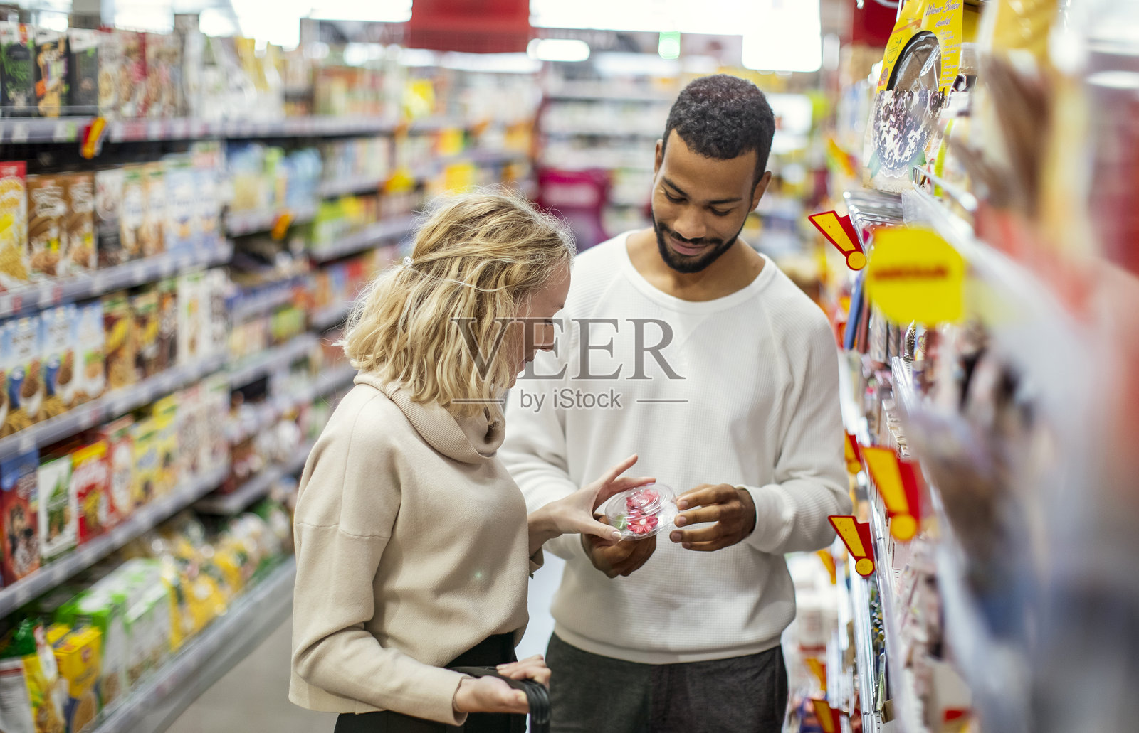 微笑的多元文化情侣在明亮的超市过道购物照片摄影图片