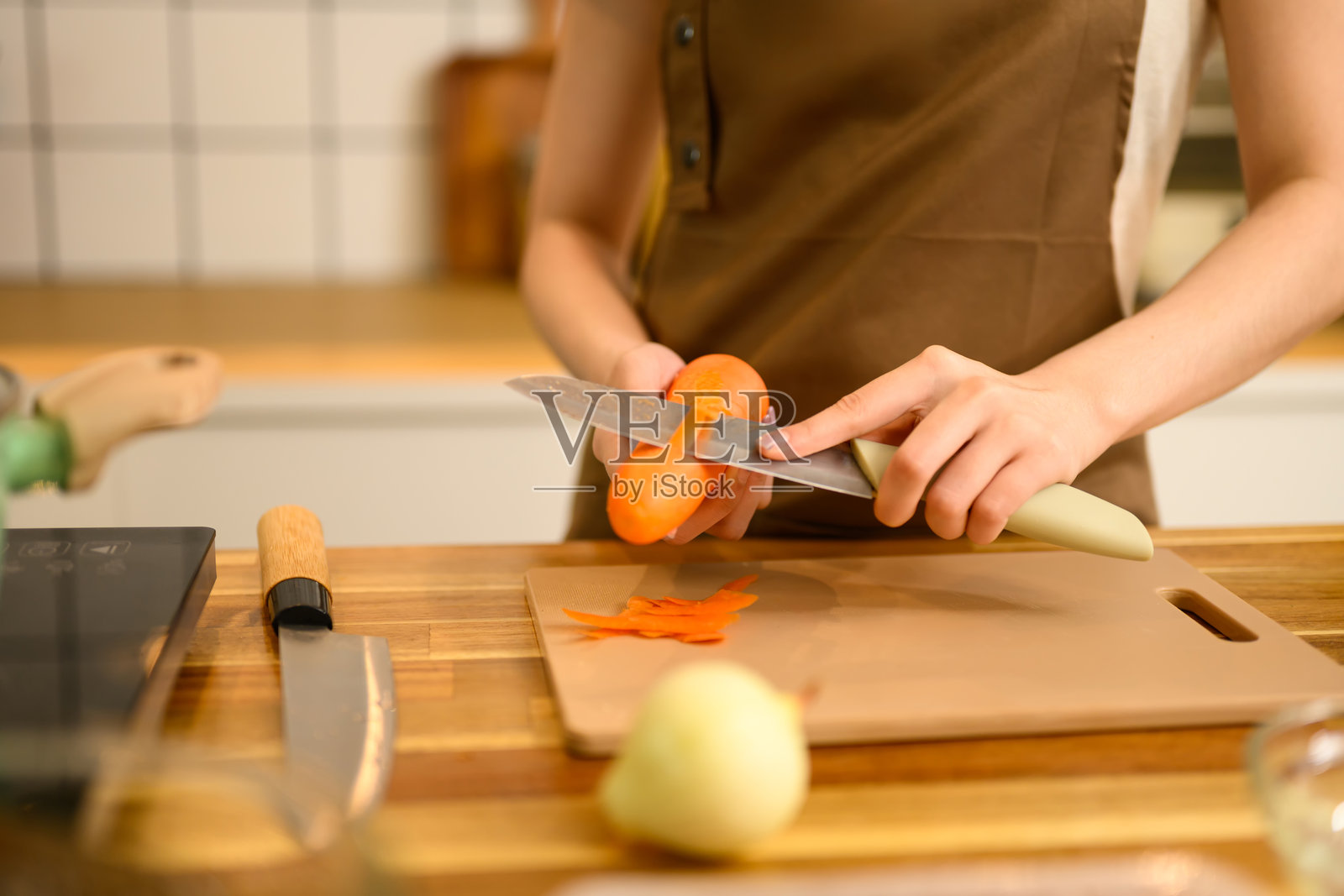 女人在准备自制意大利面食材时剥新鲜胡萝卜。照片摄影图片