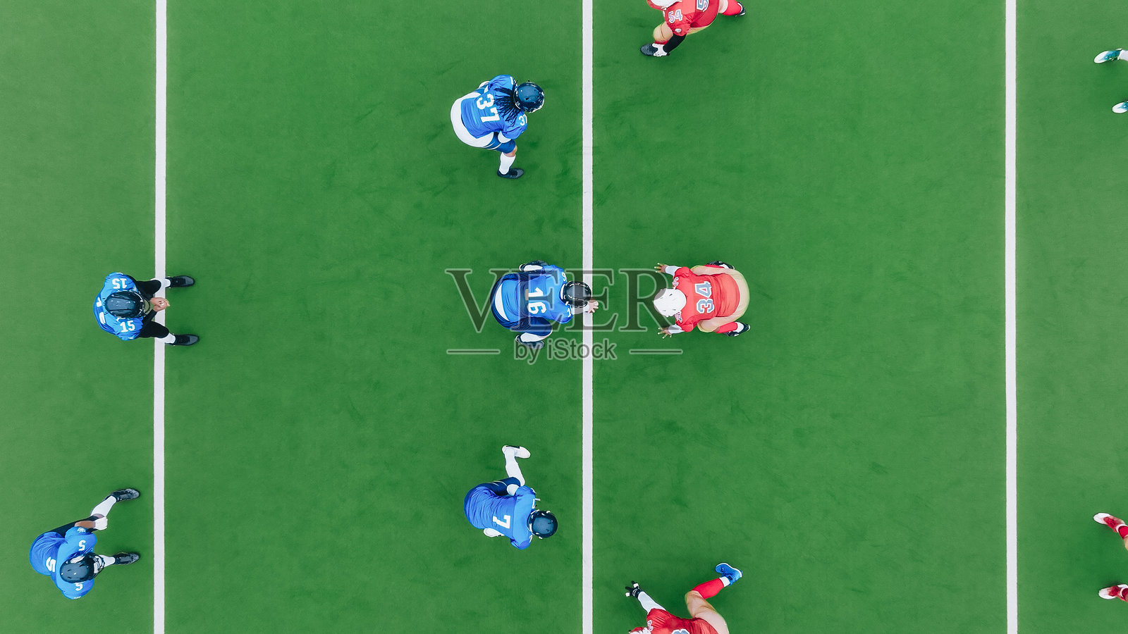 从空中俯视两支不同种族的运动队在比赛开始时就位。球被传递，球员们向前冲，而对方球队试图阻止他们。照片摄影图片