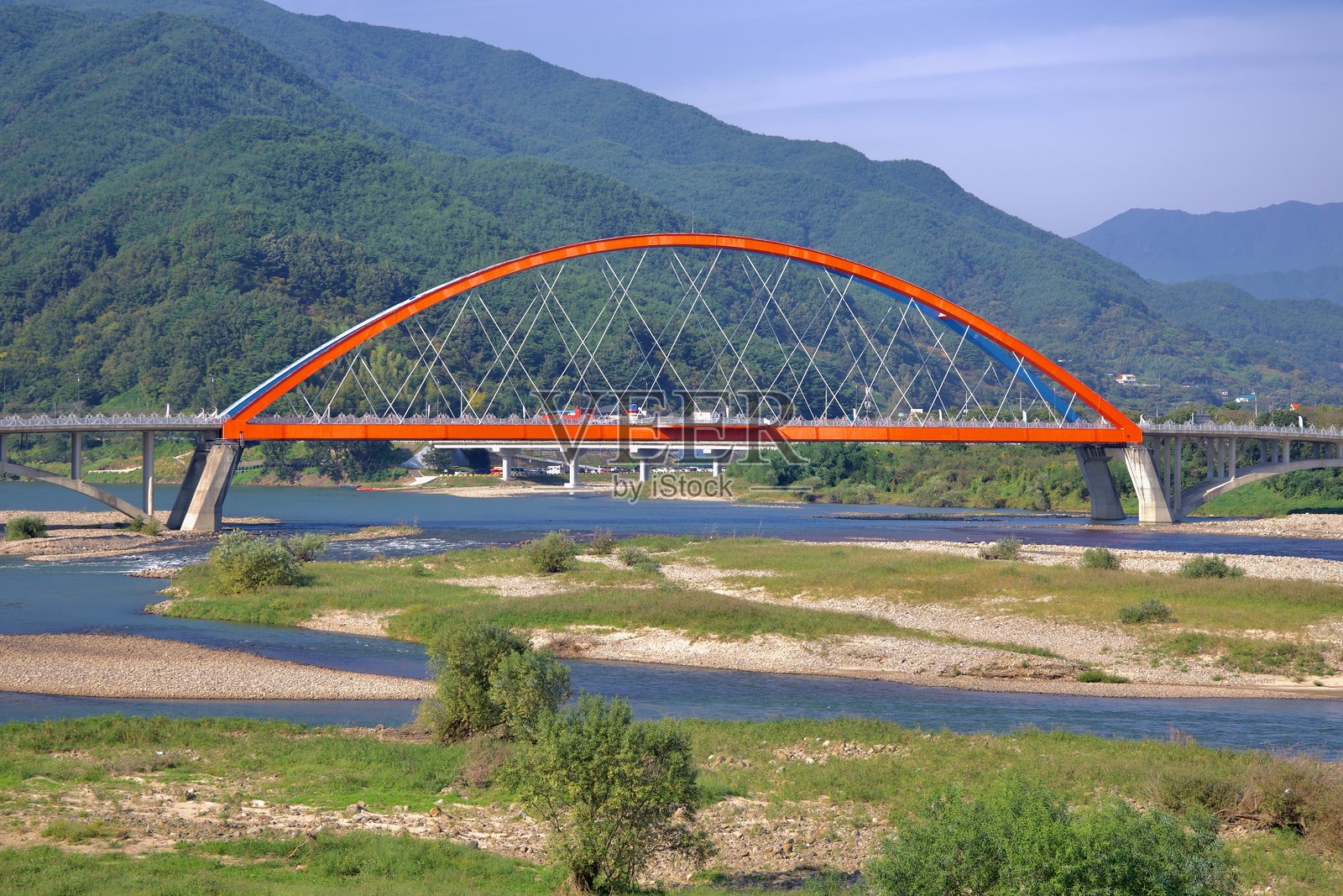 南道大桥横跨石津江,背景是绿色山脉照片摄影图片