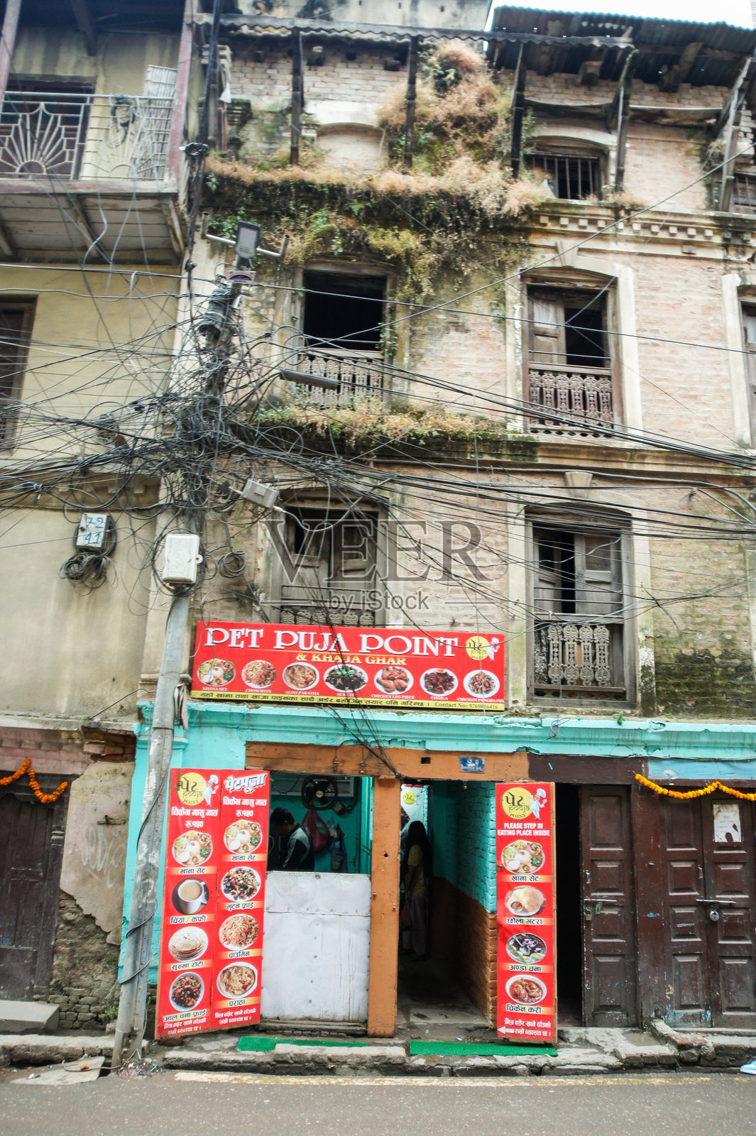 一座墙壁被植物覆盖的老房子。照片摄影图片