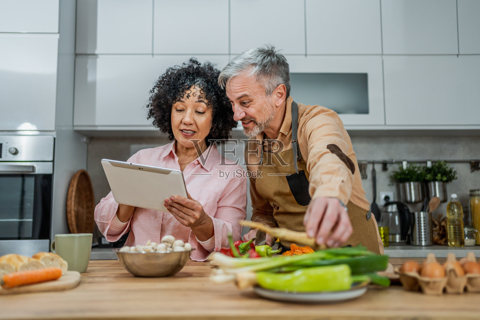 成熟夫妇使用平板电脑查找食谱照片摄影图片