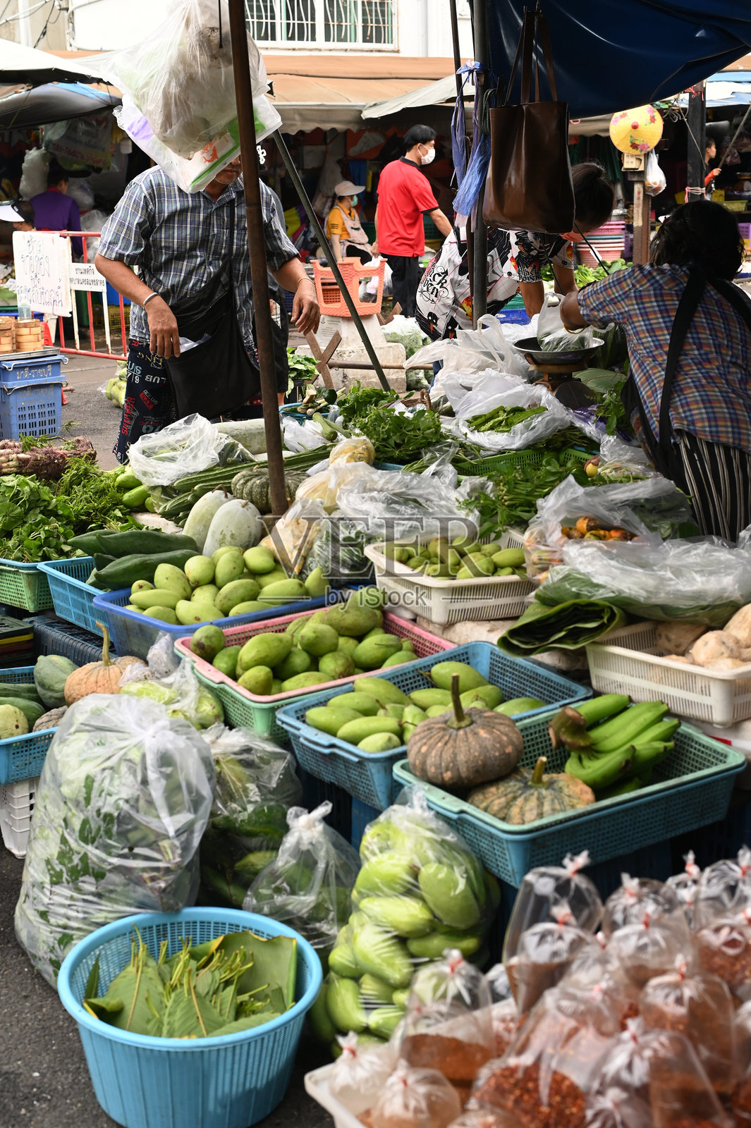 在马哈柴车站，摊贩沿铁路出售蔬菜、水果和鲜花。当火车到来时，她会保持货架不动，因为它们较低。照片摄影图片