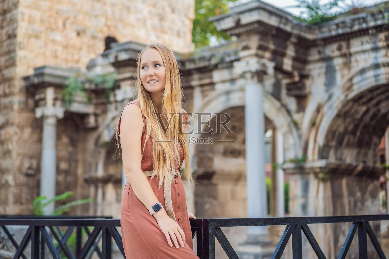 快乐的女性游客在安塔利亚老城发现有趣的地方和热门景点，游览哈德良门，土耳其的历史地标。受欢迎的旅游景点 - 安塔利亚老城的古罗马哈德良门。照片摄影图片