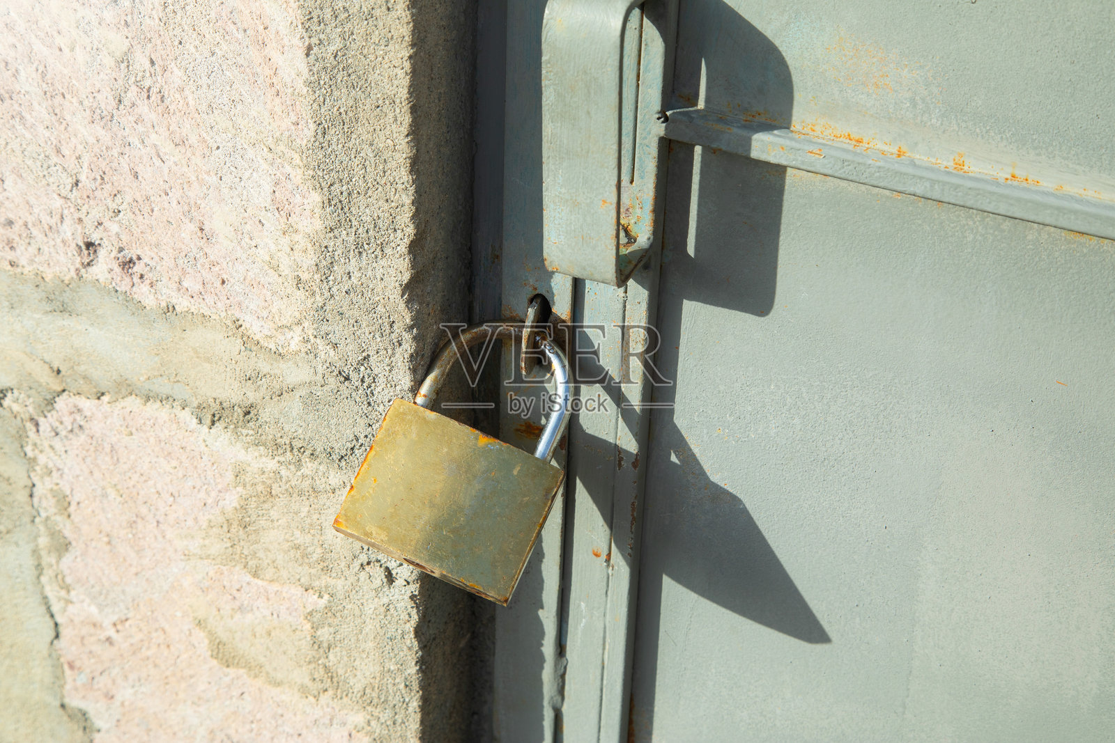 旧挂锁在金属门上。安全性照片摄影图片