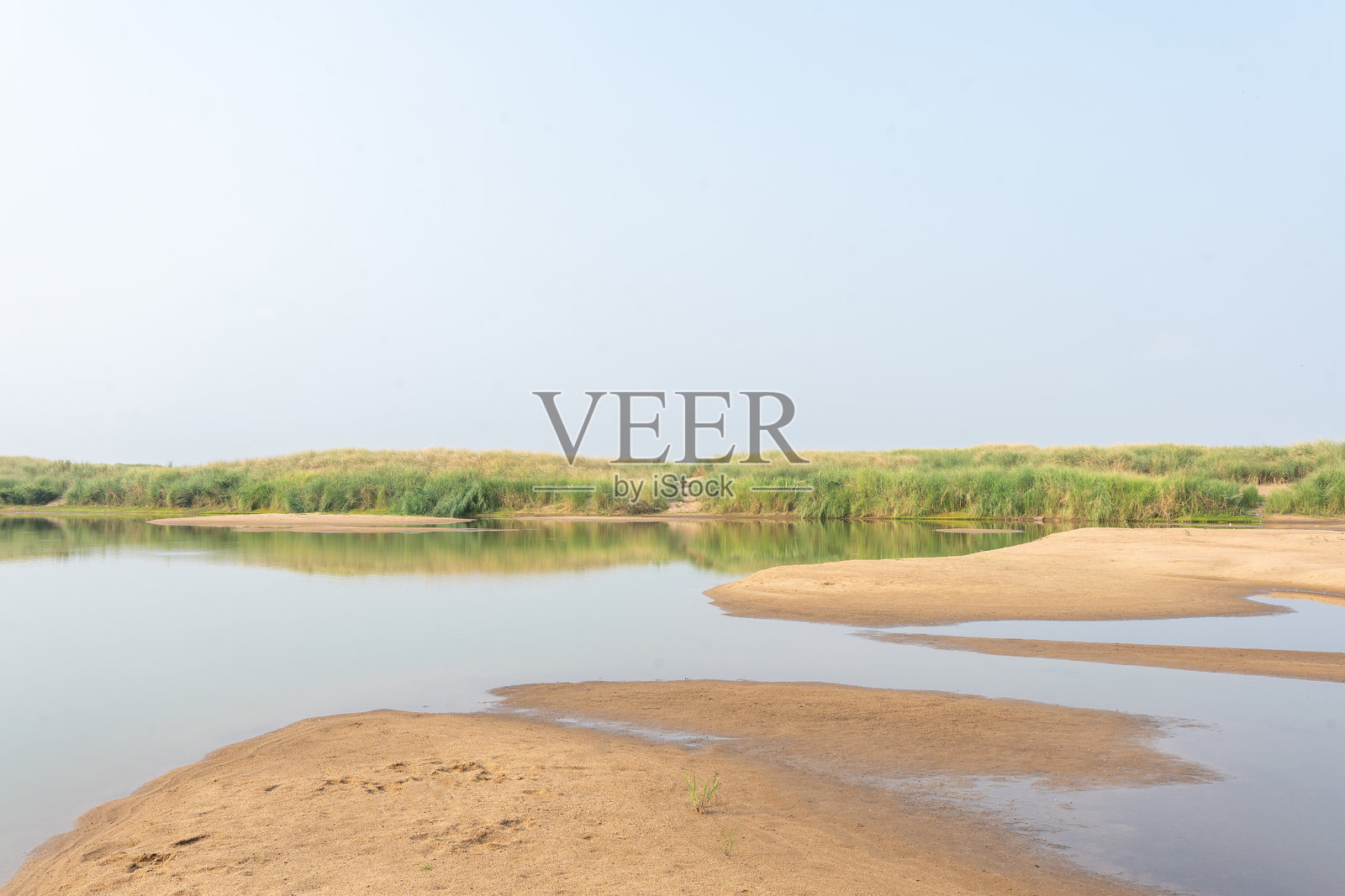 宁静的海岸风景，平静的河流，沙滩和草地沙丘照片摄影图片